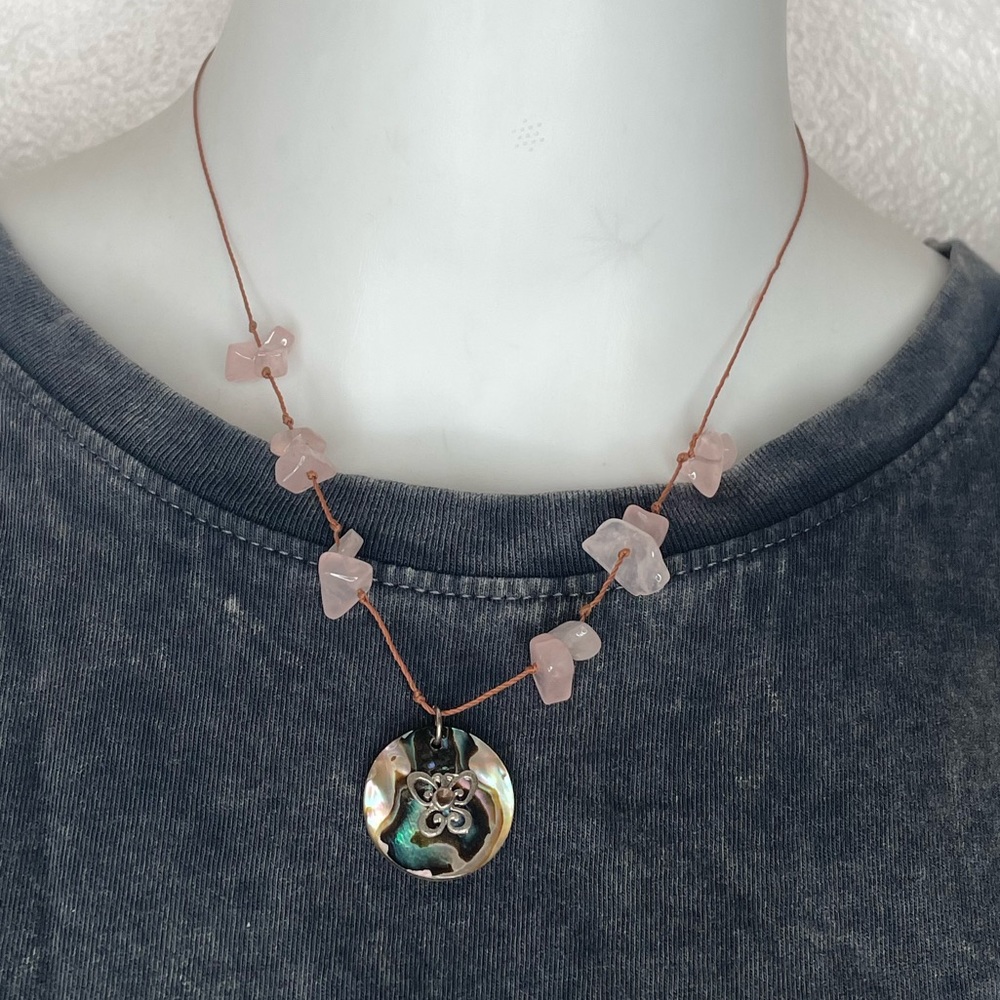 Pink stones on a thread with a butterfly charm.